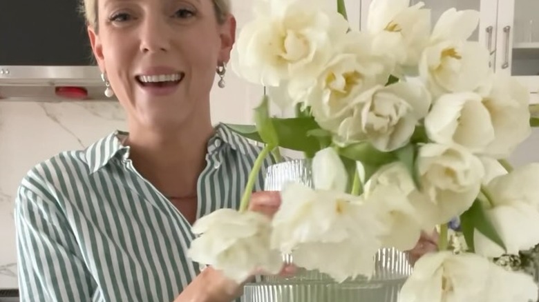 woman holding large bouquet of white double tulips