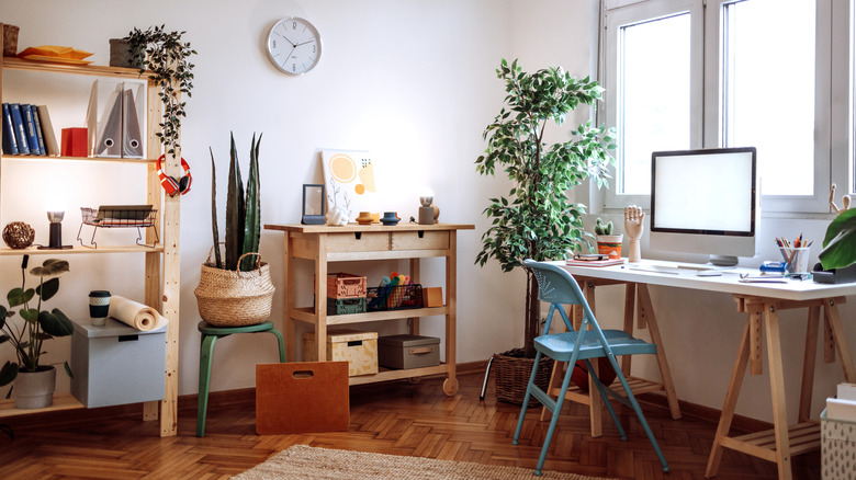 Boho cozy home office with desk supplies and art