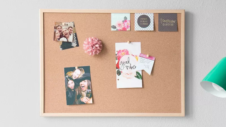 Corkboard with wooden frame on a wall with friend photos and cards