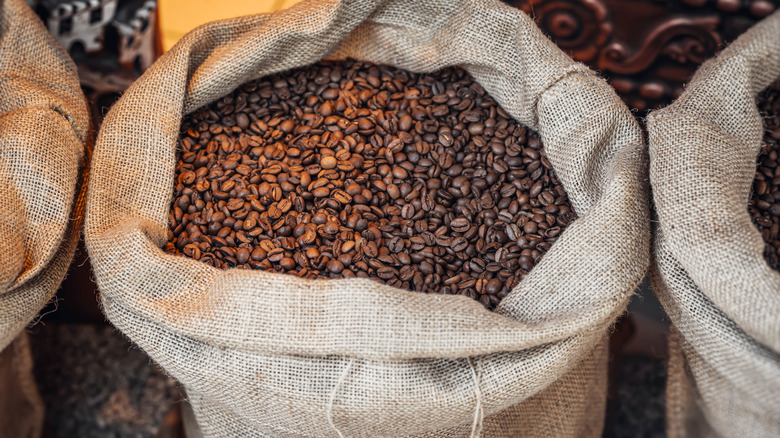 an open coffee burlap sack with coffee seeds inside