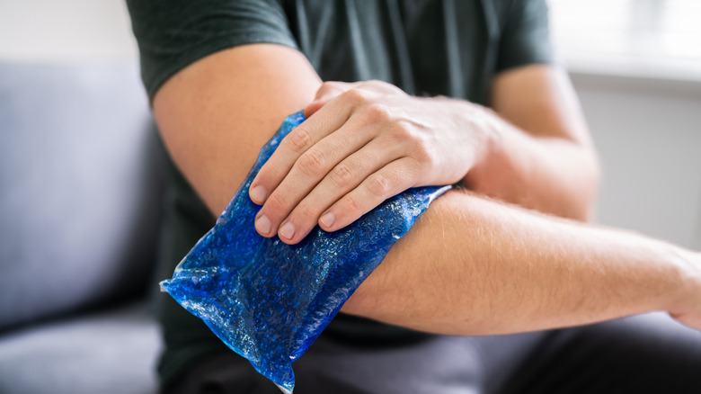 Person pressing gel ice pack against arm