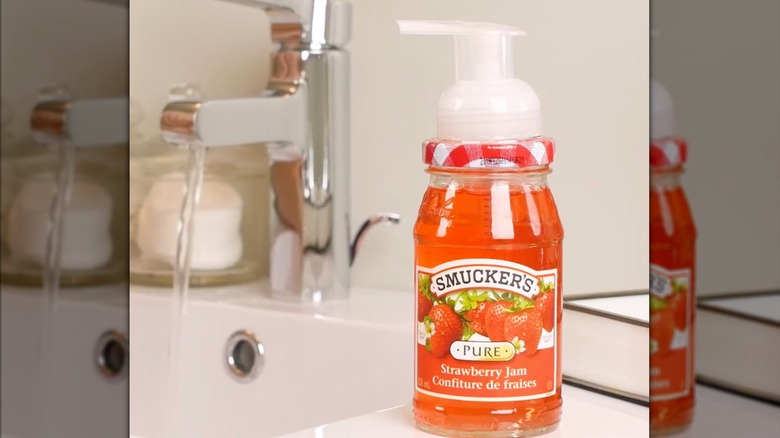 Jam jar soap dispenser next to sink with water running