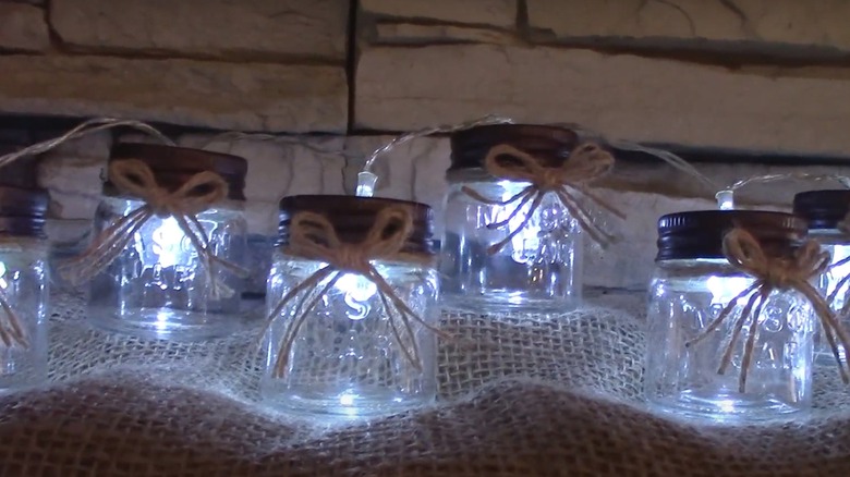 jar string light display on burlap with twine bows