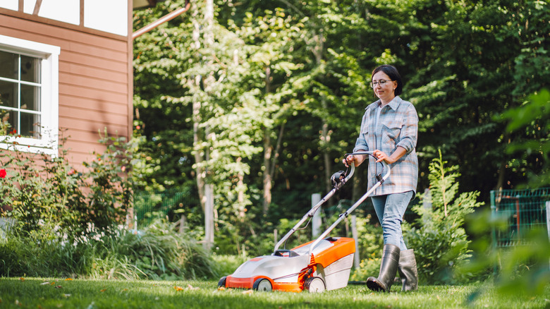 Woman mowing the lawn with a push mower