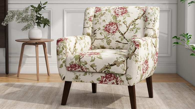 A cream and floral patterned armchair in a living room