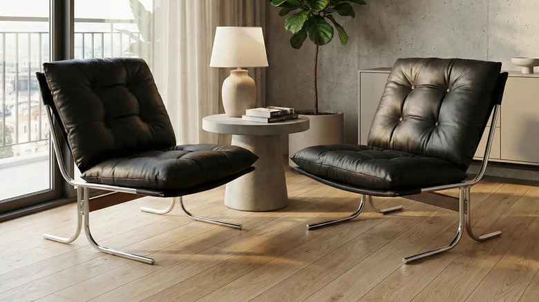 A pair of black leather chairs with chrome frames