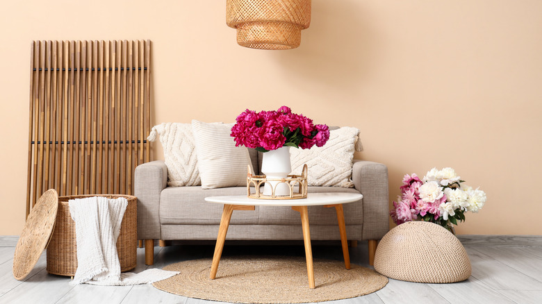 A room with peach walls and neutral furniture