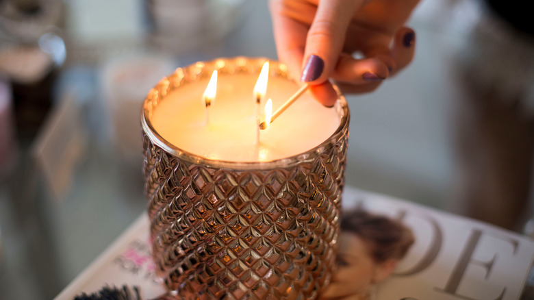 person lighting candle wicks