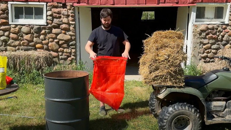 A bearded man prepares a bag to pasteurize straw.