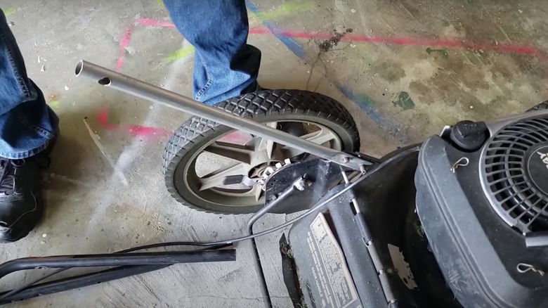 Content creator shows how to fix a broken lawn mower handle with pipe