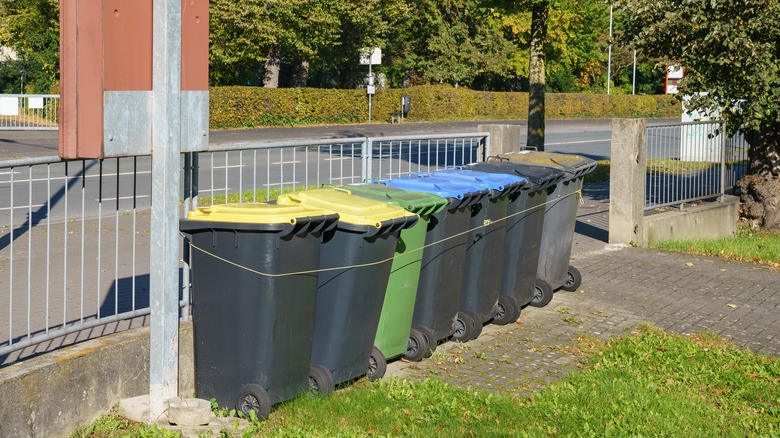 Trash cans tied to fence
