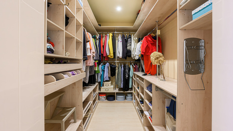 An organized walk-in closet with hanging racks and shelving