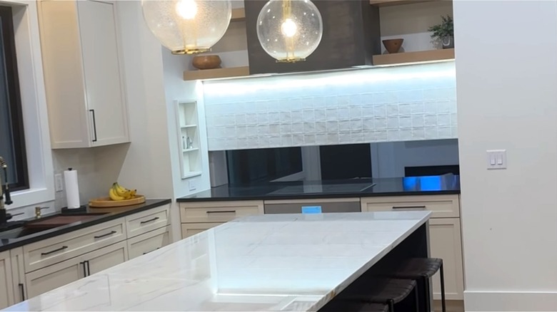 Modern kitchen with retractable backsplash that reveals the living room on the other side.