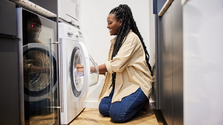 Woman smiles while doing laundry
