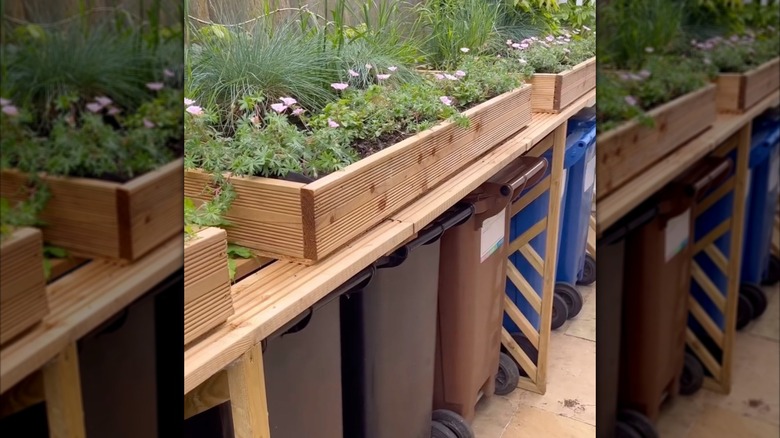Raised garden beds concealing outdoor trash bins