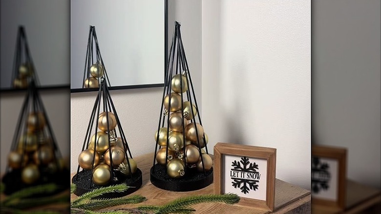 Two simple tabletop Christmas trees filled with baubles