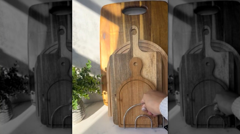 A cutting board stand made from Dollar Tree napkin holders.