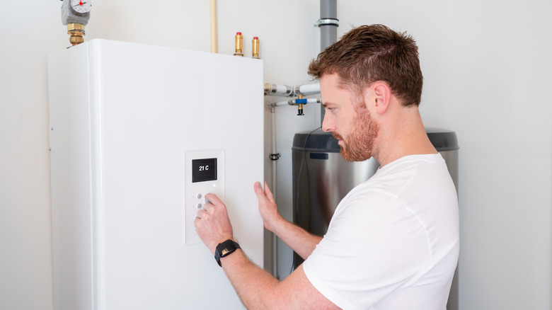 Man adjusting settings on a heat pump