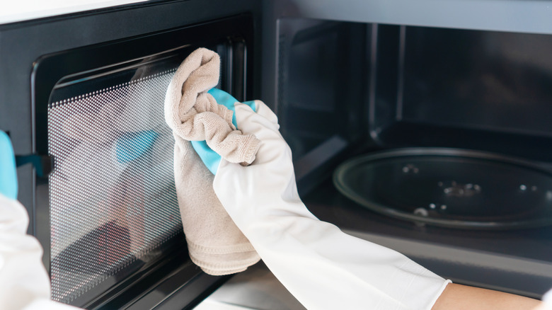 hand cleaning microwave with cloth