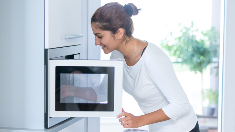 woman cleaning microwave