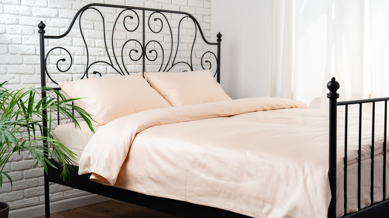 Metal bed frame with light colored sheets