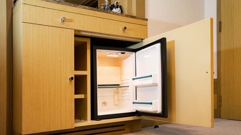 black mini fridge in cabinet