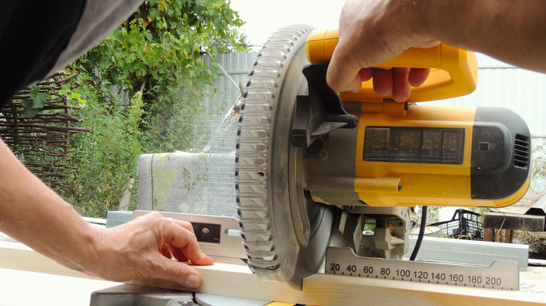 A man using a miter saw for a DIY project