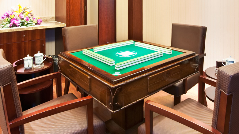 an exquisitely crafted mahjong table set up ready for playing