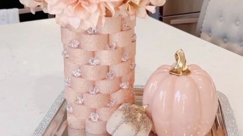 A pool noodle vase displayed on a tray with pumpkins