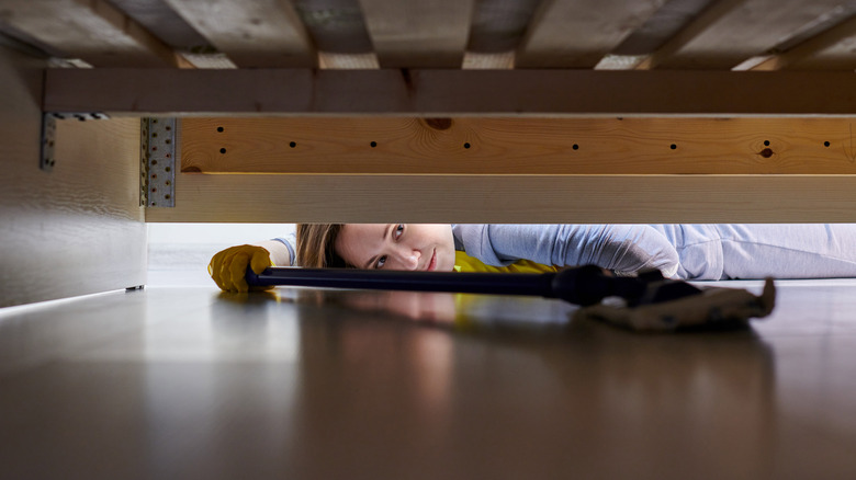 Person grabbing something under couch