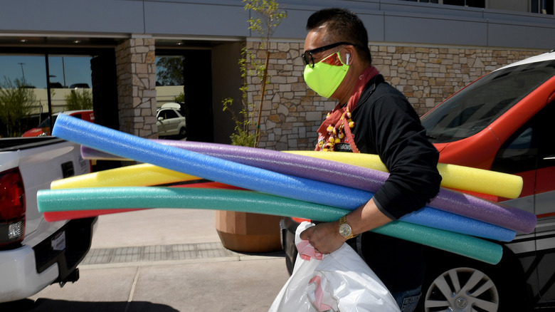 man buying pool noodles