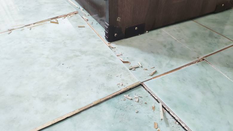 Ceramic floor tiles have buckled and cracked