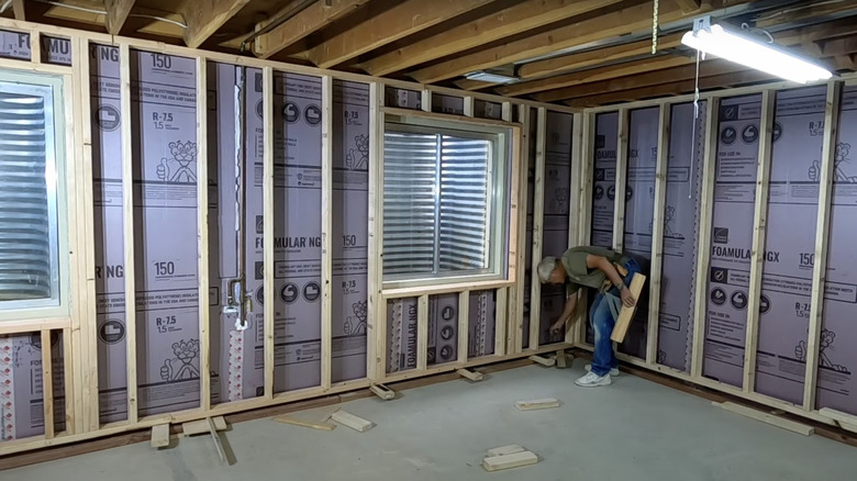 A man installs floating walls in his basement