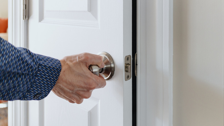 Someone grabbing a closet door knob