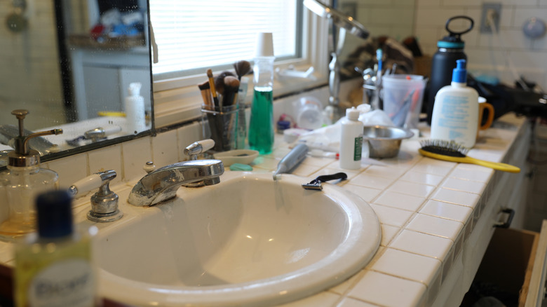 A messy bathroom countertop and sink