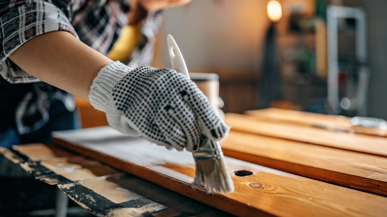 Person painting wood boards white