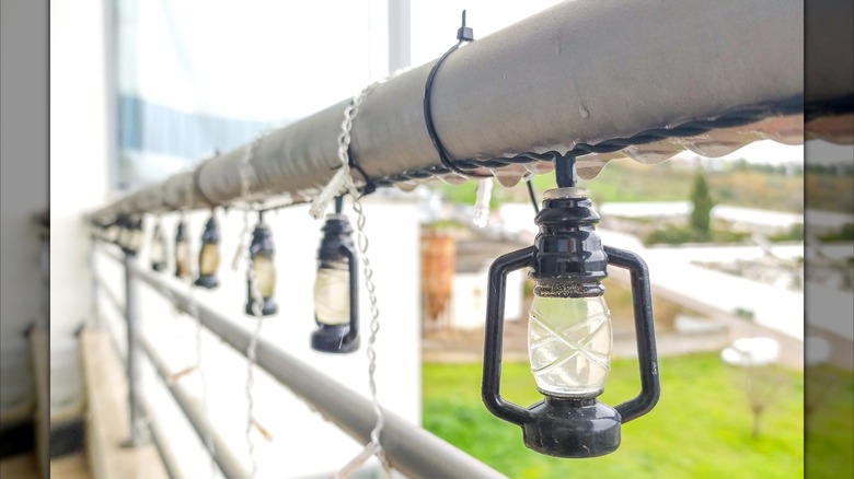 Outdoor string lights secured to railing by zip tie