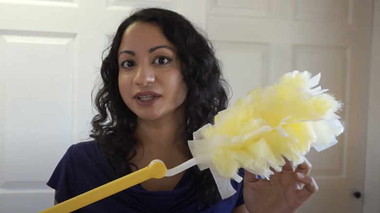 woman holding Swiffer Duster extender 