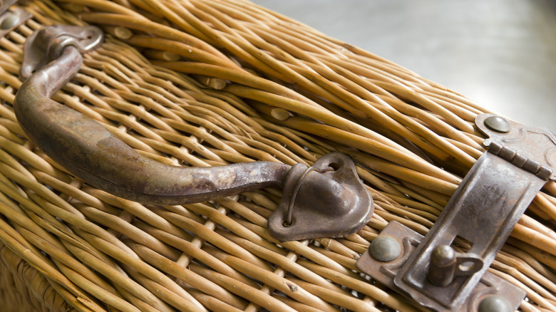 Closeup of a vintage, wicker suitcase with metal handles and clasps