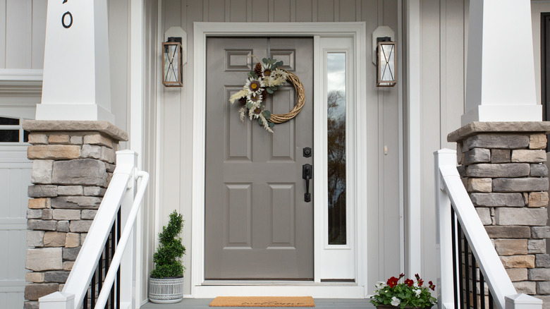 A wreath hangs on a gray front door