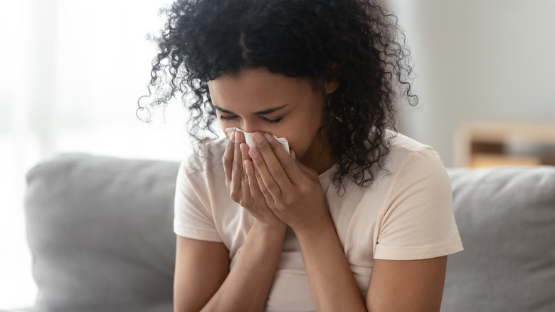 woman sneezing because of allergies