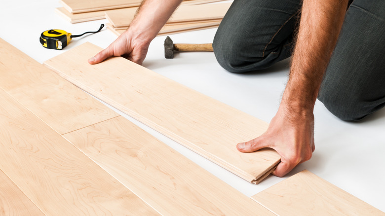 person laying wood planks