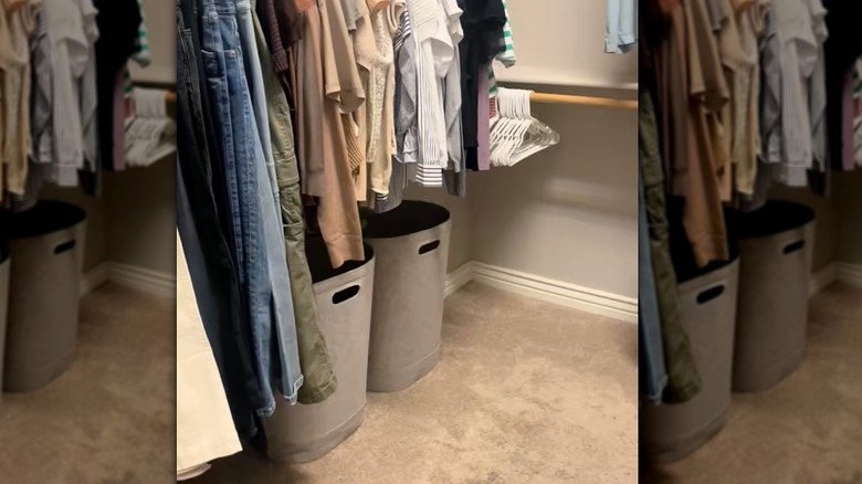 An organized walk-in closet with clothes hanging neatly.