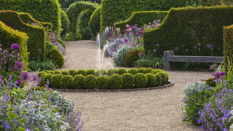 A gravel path runs through a well-manicured garden