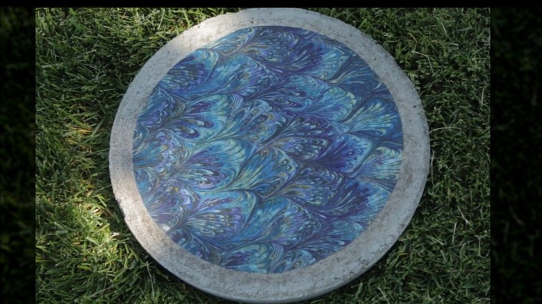A fabric covered, DIY stepping stone on grass.