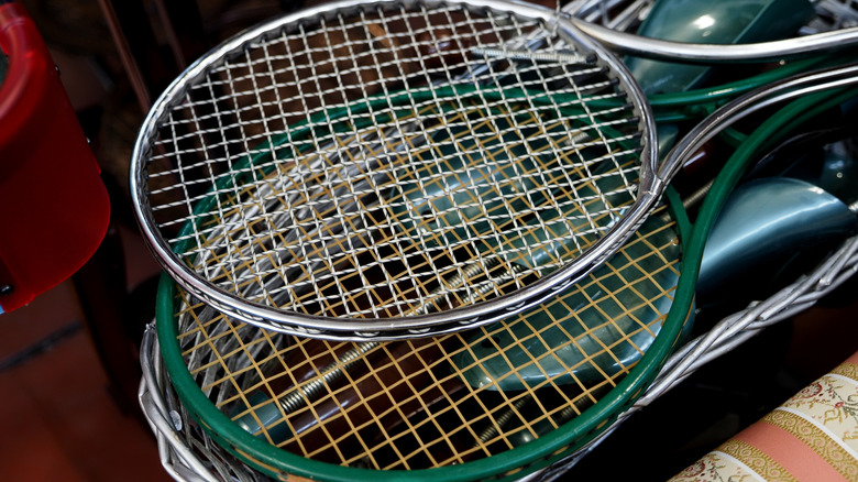 Stacked tennis rackets in silver and green