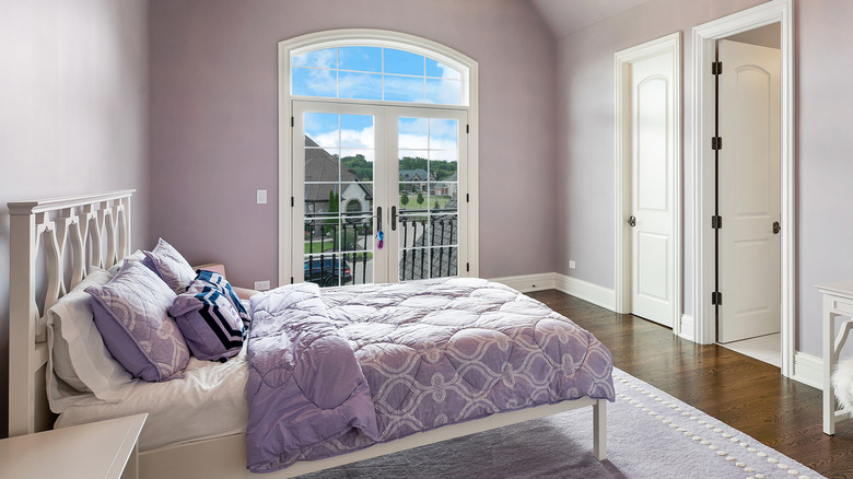Bedroom with glass french doors opening to a balcony