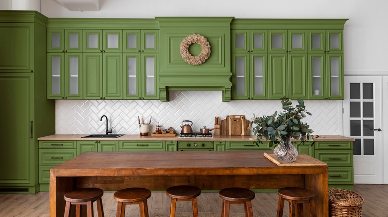 Green kitchen with wood island
