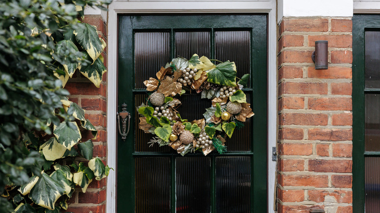 Festive gold and green wreath on a green door