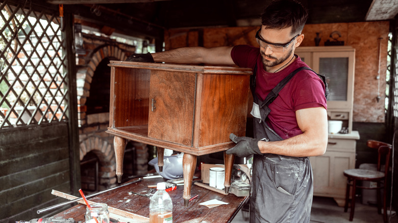 Man carrying old wood table